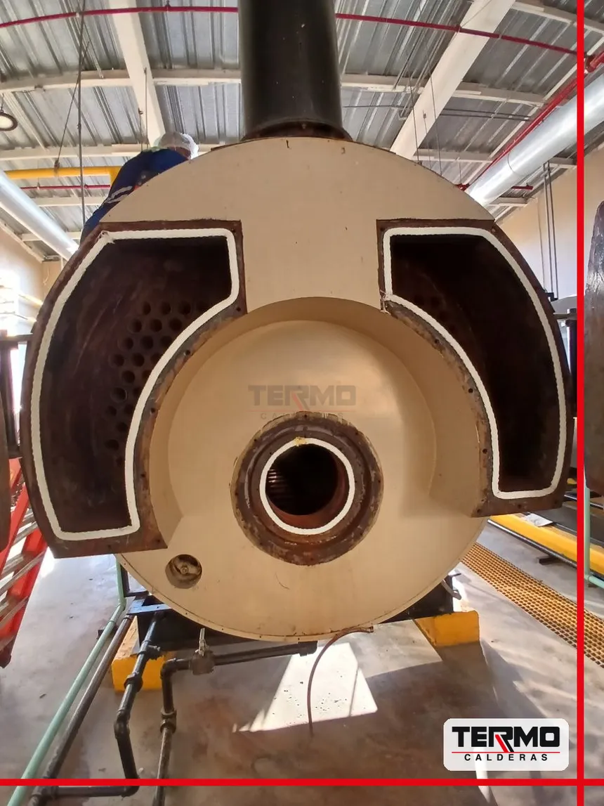 Puerta de caldera abierta mostrando refractario y empaques nuevos